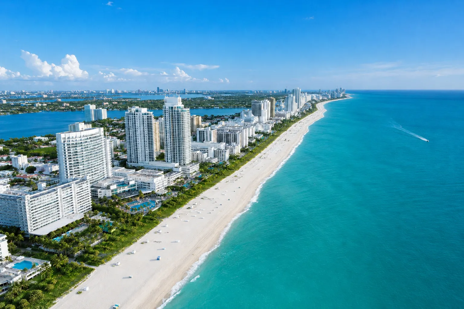 Aerial of Miami Beach at golden hour: coastline, hotels, the Atlantic horizon.